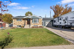 Ranch-style home with board and batten siding, concrete driveway, a garage, and brick siding