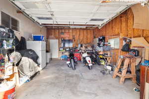 Garage featuring freestanding refrigerator and a workshop area