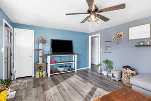 Living room with wood finished floors and a ceiling fan
