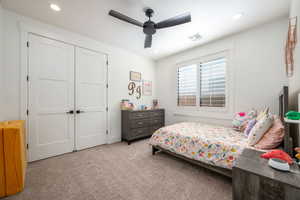 Carpeted bedroom featuring ceiling fan, recessed lighting, and a closet