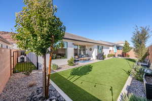 Rear view of house with a fenced backyard, a patio area, stucco siding, and an outdoor hangout area