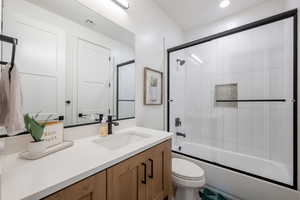 Bathroom featuring vanity and combined bath / shower with glass door