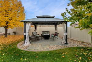 Fenced backyard with outdoor lounge area, a patio area, and a gazebo