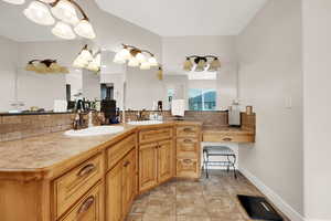 Bathroom with tasteful backsplash, double vanity, and light tile patterned floors