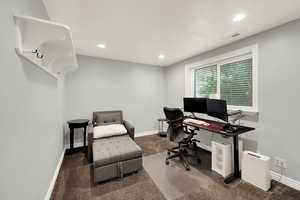 Office area featuring dark carpet and recessed lighting