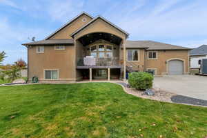 Back of property featuring stucco siding, a lawn, a patio area, and driveway