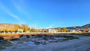 Water view featuring a mountain backdrop and nearby suburban area