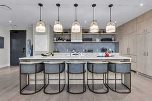 Kitchen featuring open shelves, a breakfast bar area, pendant lighting, and recessed lighting