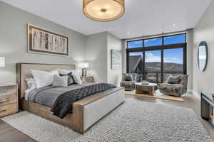 Bedroom featuring wood finished floors, floor to ceiling windows, and access to outside