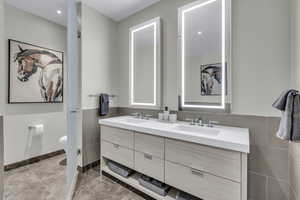 Bathroom with double vanity and tile walls