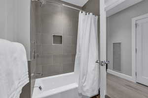 Bathroom featuring shower / tub combo and wood finished floors