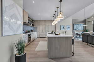 Kitchen featuring open shelves, open floor plan, pendant lighting, modern cabinets, and recessed lighting