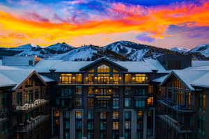 Back of property at dusk featuring a mountain view