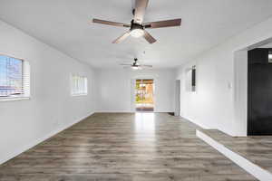 Unfurnished room with wood finished floors and a ceiling fan