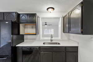 Kitchen featuring black appliances, a textured ceiling, light stone counters, and a ceiling fan