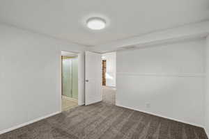 Spare room featuring carpet floors and baseboards