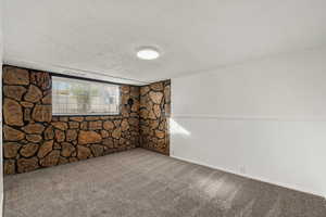 Empty room with carpet floors and a textured ceiling