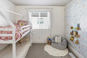 Bedroom with baseboards and wallpapered walls