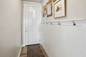 Doorway to outside with wood finished floors and baseboards