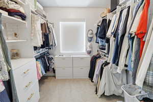 Walk in closet with light carpet