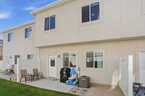 Back of property with a patio and stucco siding