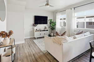 Living area with light wood finished floors and a ceiling fan