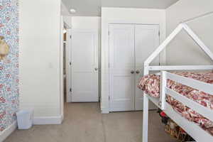 Bedroom featuring light colored carpet and a closet
