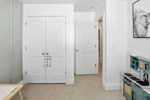 Bedroom featuring light colored carpet and a closet