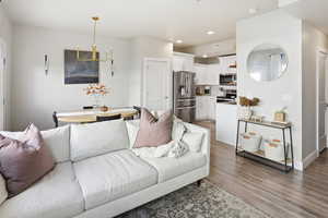 Living area featuring recessed lighting, light wood-type flooring, and a chandelier