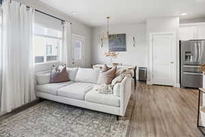 Living area featuring light wood-style floors, a chandelier, and recessed lighting