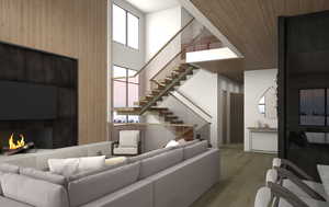 2-story great room with a wood-burning fireplace and glass railings, with a staircase in the background.