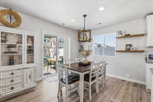 Dining area with recessed lighting, light wood-type flooring, and a chandelier