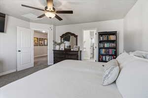 Carpeted bedroom featuring a ceiling fan, a textured ceiling, and ensuite bathroom