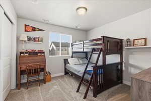 Bedroom with light carpet and a closet