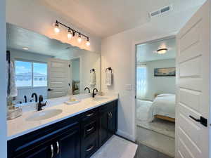 Bathroom with a textured ceiling, double vanity, plenty of natural light, and ensuite bath