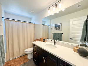 Bathroom featuring a textured ceiling and vanity