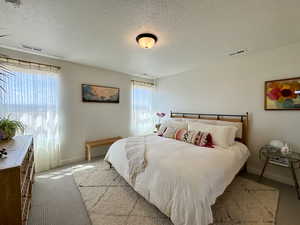 Bedroom featuring a textured ceiling and carpet flooring