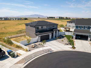 View of front facade with driveway, a fenced backyard, a view of rural / pastoral area, a garage, and a mountain view