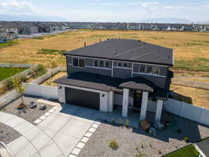 View of front of property featuring a fenced backyard, driveway, a garage, a mountain view, and a residential view