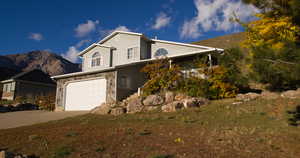 View of front facade with concrete driveway, an attached garage, and a mountain view