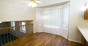 Unfurnished dining area featuring dark wood-style floors and a ceiling fan