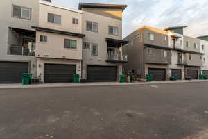 Back of property featuring a balcony, stucco siding, and an attached garage