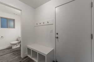 Mudroom with dark wood-type flooring and baseboards