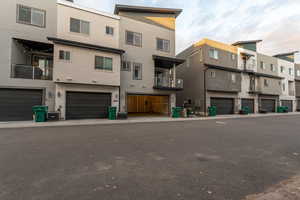 Back of property featuring stucco siding, a balcony, and a residential view