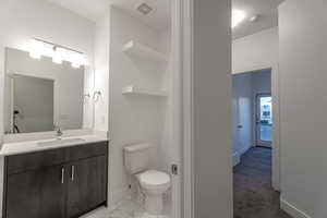 Half bath featuring vanity and baseboards