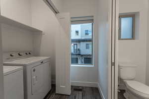Washroom featuring dark wood-style flooring and washer and clothes dryer
