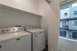 Laundry room featuring washing machine and dryer and dark wood finished floors