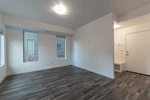 Unfurnished room with dark wood-type flooring and a textured ceiling