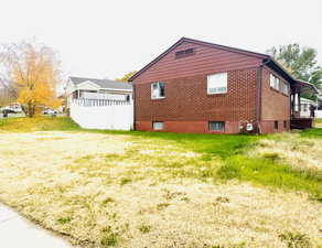 View of side of home with brick siding and a yard