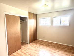 Unfurnished bedroom featuring light wood-style floors and a closet